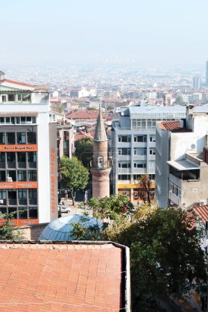 Téléchargez les photos : Bursa-Turquie 09.16.2023 Immeubles d'appartements de plusieurs étages, atmosphère brumeuse, mosquée historique avec un seul minaret et panneaux de signalisation. - en image libre de droit