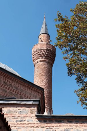 Téléchargez les photos : Le minaret de la mosquée Yigit Kohne, construite au XVe siècle à Bursa, capitale de l'Empire ottoman sur ciel bleu - en image libre de droit