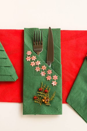Téléchargez les photos : Couleur rouge et verte, papier motif Noël serviettes de Noël diverses plié avec couverts fixés sur la surface blanche - en image libre de droit