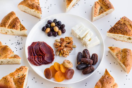Téléchargez les photos : Ramadan turc traditionnel, Iftar Menu de départ Assiette avec viande séchée, bacon, fruits et tranches de pain Ramadan sur surface blanche - en image libre de droit