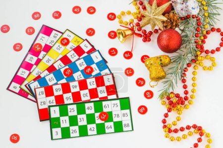 Téléchargez les photos : Jeu de bingo coloré cartes et numéros sur fond blanc avec ornements de Noël - en image libre de droit
