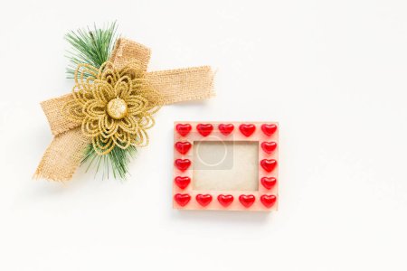 Téléchargez les photos : Noeud de Noël en tissu de jute sur une surface blanche cadre vide avec coeur concept de Noël - en image libre de droit