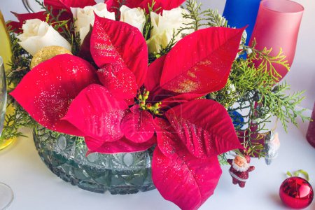 Téléchargez les photos : Posettia frais conçu avec des roses blanches avec des verres à champagne sur table blanche - en image libre de droit