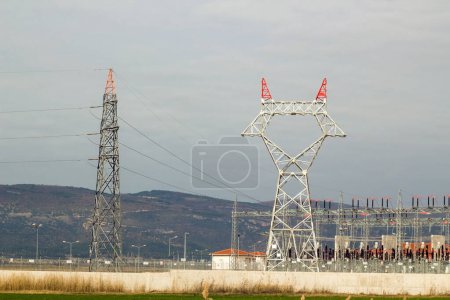 Téléchargez les photos : Grand poteau électrique avec câbles en acier non encore connectés est avec la centrale électrique, dans la campagne - en image libre de droit