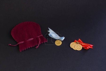 Téléchargez les photos : Pièces d'or turques traditionnelles avec rubans bleus et rouges avec pochette en or velours sur surface noire - en image libre de droit