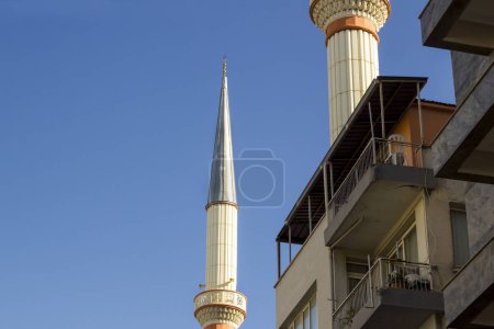 Téléchargez les photos : Deux minarets très proches de l'immeuble, sur le ciel bleu avec espace de copie - en image libre de droit
