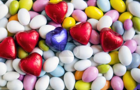 Téléchargez les photos : Des bonbons aux amandes colorées ont été conçus avec des chocolats enveloppés en forme de cœur. - en image libre de droit