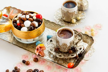 Téléchargez les photos : Bonbons turcs traditionnels aux amandes dures conçus dans un plateau vintage élégant avec café. - en image libre de droit