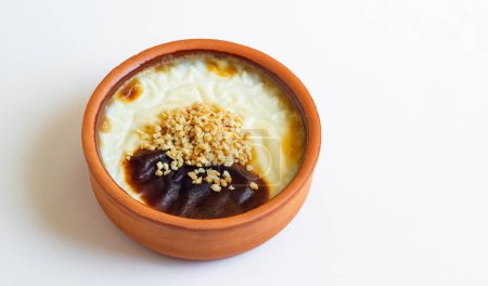 Téléchargez les photos : Pudding de riz cuit au four de style turc traditionnel dans un bol à casserole, sur surface blanche avec espace de copie - en image libre de droit
