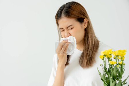 Photo for Pollen Allergies, young woman sneezing in a handkerchief or blowing in a wipe, allergic to wild spring flowers or blossoms during spring. allergic reaction, respiratory system problems, runny nose. - Royalty Free Image