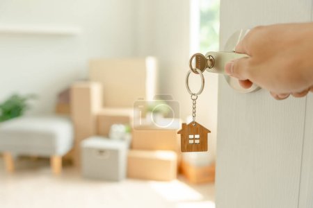 Foto de Moving house, relocation. Man hold key house keychain in new apartment. move in new home. Buy or rent real estate. flat tenancy, leasehold property, new landlord, investment, dwelling, loan, mortgage. - Imagen libre de derechos
