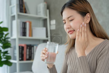 Photo for Asian woman feel sensitive teeth after drinking cold, female suffer tooth, decay problems, dental care, tooth extraction, decay problem, bad breath, Gingival Recession, Oral Hygiene instruction - Royalty Free Image