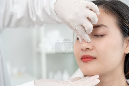 Schönheitsoperationen, Schönheitsoperationen, Chirurgen oder Kosmetikerinnen, die das Gesicht der Frau berühren, chirurgische Eingriffe, bei denen die Form der Nase verändert wird, der Arzt untersucht die Nase des Patienten vor der Nasenkorrektur, medizinische Hilfe, Gesundheit