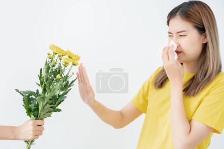 Photo for Pollen Allergies, asian young woman sneezing in a handkerchief or blowing in a wipe, allergic to wild spring flowers or blossoms during spring. allergic reaction, respiratory system problem - Royalty Free Image