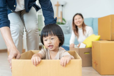 Moving house, relocation. Family smile and happy after buy new apartment, inside the room was a cardboard box contain personal belongings and furniture. move in the new apartment or condominium