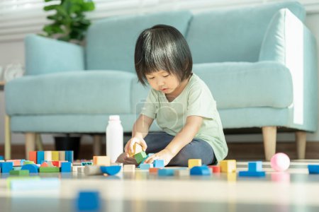 Glückliches asiatisches Kind beim Spielen und Lernen von Spielzeugblöcken. Die Kinder sind zu Hause sehr glücklich und aufgeregt. Kinder haben viel Spaß beim Spielen, Aktivitäten, Entwicklung, Aufmerksamkeitsdefizit-Hyperaktivitätsstörung