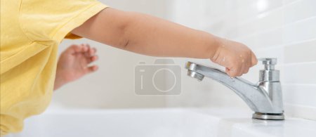 Kleines Kind dreht immer wieder das fließende Wasser im Badezimmer ab, um die Umwelt zu schützen. Begrünung des Planeten, Reduzierung der globalen Erwärmung, Welt retten, Leben, Zukunft, Risiko Energie, Krise, Wassertag