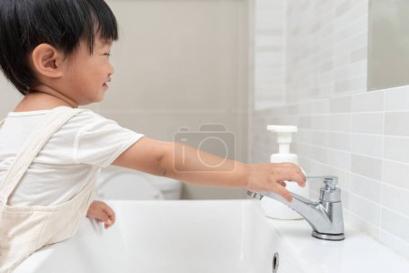 Wasser sparen. Kleines Kind dreht immer wieder das fließende Wasser im Badezimmer ab, um die Umwelt zu schützen. Begrünung des Planeten, Reduzierung der globalen Erwärmung, Welt retten, Leben, Zukunft, Risiko Energie, Krise, Wassertag