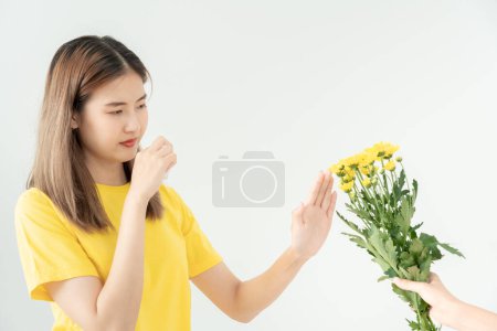 Allergies au pollen, jeune femme asiatique éternuant dans un mouchoir ou soufflant dans une lingette, allergique aux fleurs sauvages du printemps ou aux fleurs au printemps. réaction allergique, problèmes respiratoires