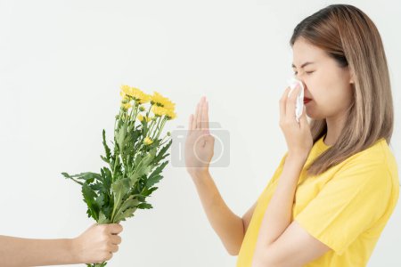 Photo for Pollen Allergies, asian young woman sneezing in a handkerchief or blowing in a wipe, allergic to wild spring flowers or blossoms during spring. allergic reaction, respiratory system problems - Royalty Free Image