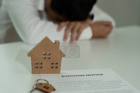Photo for Business man is stressed due to imminent seizure of assets, debts, financial problems, loans, guarantees document with the text eviction notice, debt, property, loan, agent, bankruptc - Royalty Free Image