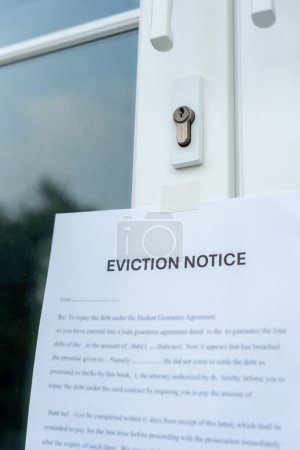 Photo for Document with the text eviction notice, Civil servant sticks a notice of eviction of the tenants hangs on the door of the house, debt, property, loan, agent, bankruptcy, dispossess, proble - Royalty Free Image