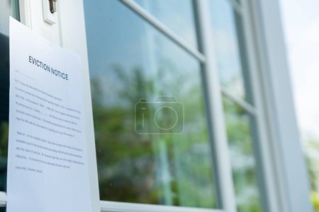 Photo for Document with the text eviction notice, Civil servant sticks a notice of eviction of the tenants hangs on the door of the house, debt, property, loan, agent, bankruptcy, dispossess, problem - Royalty Free Image