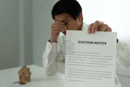Photo for Document with the text eviction notice, Civil servant sticks a notice of eviction of the tenants hangs on the door of the house, debt, property, loan, agent, bankruptcy, dispossess, problem - Royalty Free Image