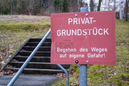 Warnung / Hinweisschild rot-weien mit der Aufschrift: "Privatgrundstück - Begehen des Weges auf eigene Gefahr!"