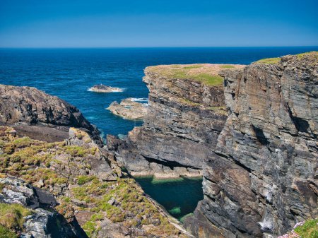 Estratos rocosos expuestos en acantilados costeros en la costa rocosa y escarpada del Atlántico de la Isla de Lewis en las Hébridas Exteriores, Escocia, Reino Unido. Tomado en un día soleado en verano.