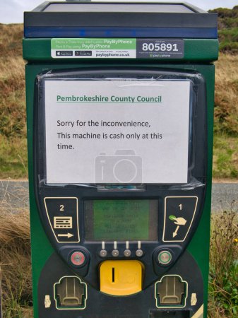 Photo for A temporary paper printed sign on a parking meter at Newgale Beach on the Pembrokeshire Coast in Wales, UK advises motorists that only cash payments can be made. - Royalty Free Image