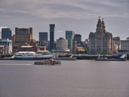 Photo for The River Mersey ferry Snowdrop passes the historic Liverpool waterfront. The Isle of Man ferry HSC Manannan appears in the background. - Royalty Free Image