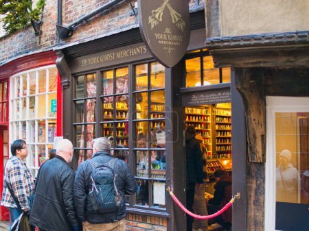 Téléchargez les photos : York, Royaume-Uni - 21 nov.2023 : Touristes à l'extérieur des locaux de vente au détail de The York Ghost Merchants, une attraction touristique populaire dans le quartier commerçant Shambles de la ville de York dans le nord de l'Angleterre. - en image libre de droit