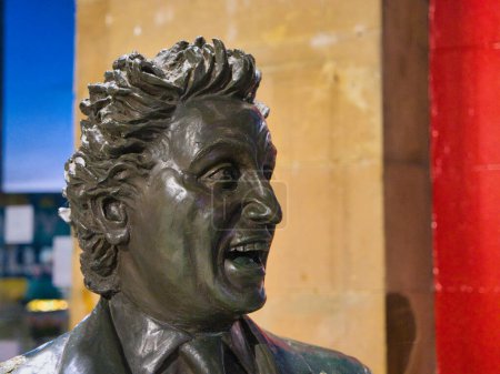 Téléchargez les photos : Liverpool, Royaume-Uni - 4 janvier 2024 : La tête et les épaules de la statue en bronze de Ken Dodd par Tom Murphy à Liverpool Lime street Station sur Merseyside dans le nord-ouest du Royaume-Uni. - en image libre de droit