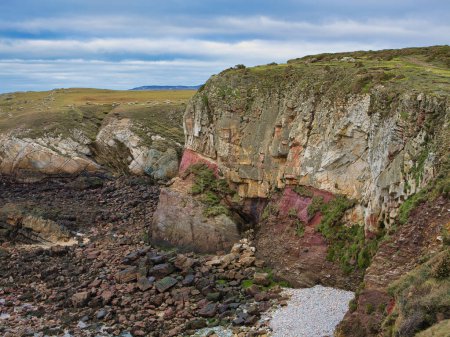 Falaises côtières colorées sur le sentier côtier du Pays de Galles. Les roches appartiennent au groupe de New Harbour - schiste de Mica et psammite, substratum rocheux métamorphique formé il y a 635 à 541 millions d'années dans la période Ediacaran.