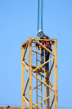 Photo for Construction worker on the part of a tower crane - Royalty Free Image
