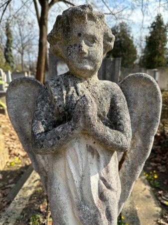 Estatuilla de ángel en el cementerio público sobre una lápida