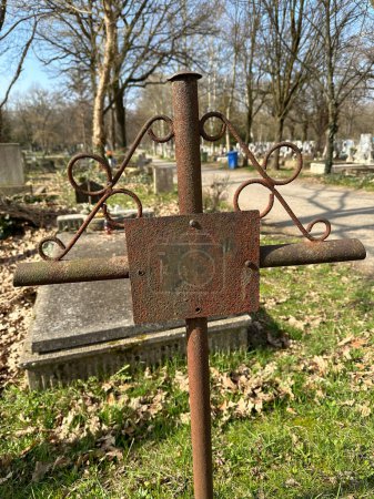 Antigua lápida de metal oxidado en el cementerio público