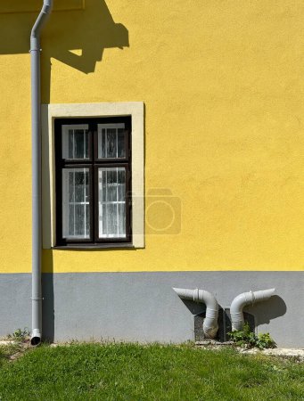 Yellow wall with eaves and pipes