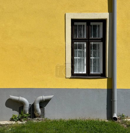 Yellow wall with eaves and pipes