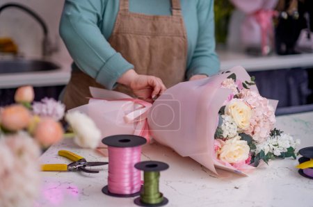 Téléchargez les photos : Fleuriste femme fait la conception florale pour mariage, décorateur préparer des cadeaux de fleurs pour les anniversaires et les fêtes. - en image libre de droit