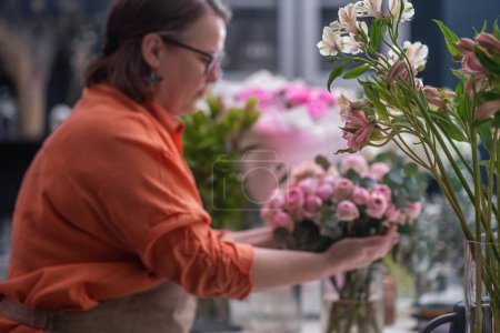 Téléchargez les photos : Studio de design floral. boutique de fleurs bouquet de préparation de couleur rose vif fleurs fraîches gros plan - en image libre de droit