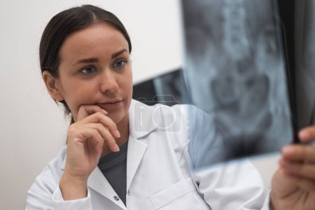 primer plano del médico preocupado mira la radiografía radiológica para evaluar la condición de los pacientes como parte de la atención médica. 