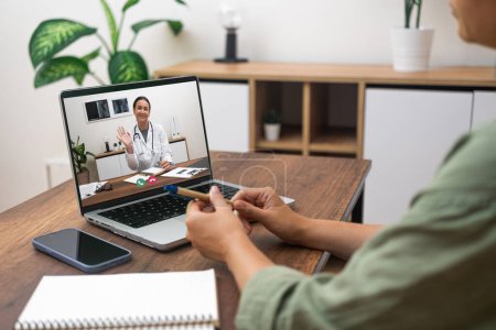 Téléchargez les photos : Patient participant à une séance de télémédecine avec un médecin sur un ordinateur portable à la maison. - en image libre de droit
