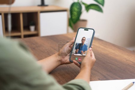 Close-up of a telehealth appointment with a medical professional on a smartphone.