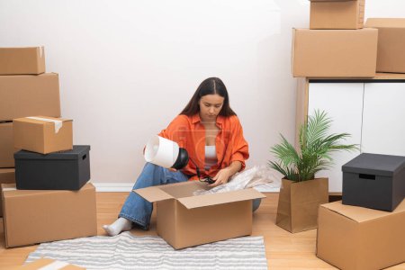 In her new rented home, a young womans face lights up with delight as she unpacks, savoring the excitement of relocation