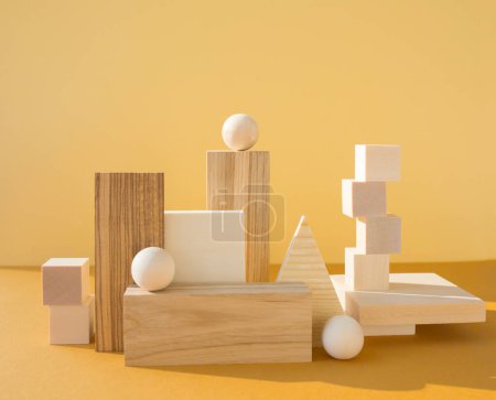Geometrische Komposition mit vielen dreidimensionalen Holzfiguren auf gelbem Hintergrund. Balance, Kunst und Designkonzept.