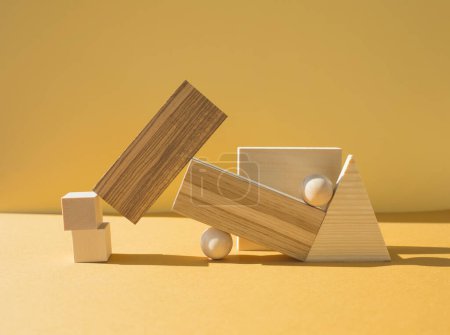 Geometrische Formen aus Holz. Geometrische Komposition. Szene mit geometrischen Formen auf gelbem Hintergrund.