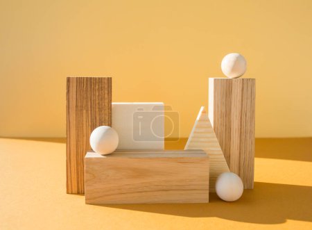 Geometrische Figuren Stillleben Komposition. Viele dreidimensionale Holzobjekte auf gelbem Hintergrund. Balance, Kunst und Designkonzept.