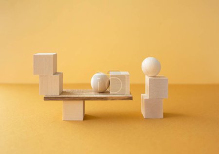 Composición geométrica horizontal equilibrada de diferentes figuras de madera sobre fondo amarillo.